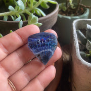 guitar pick with cremation ocean blue green in hand